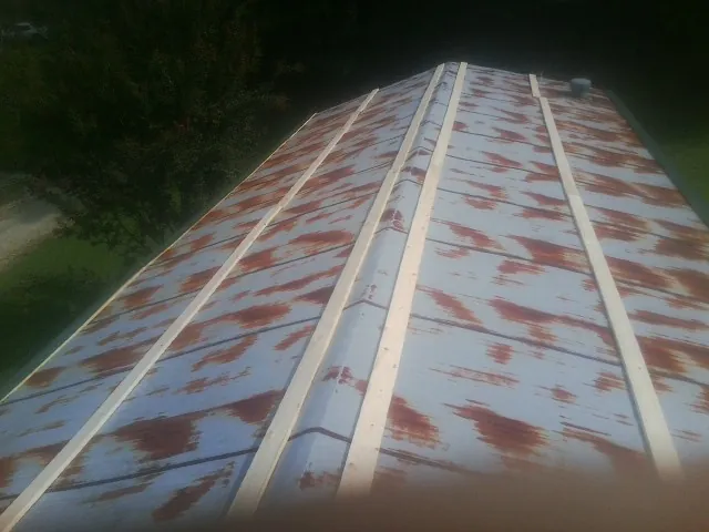 Rusted metal roof panels with new wood purlins before replacement — Storm Damage Roof Repair in Lusk by Roofing Brothers